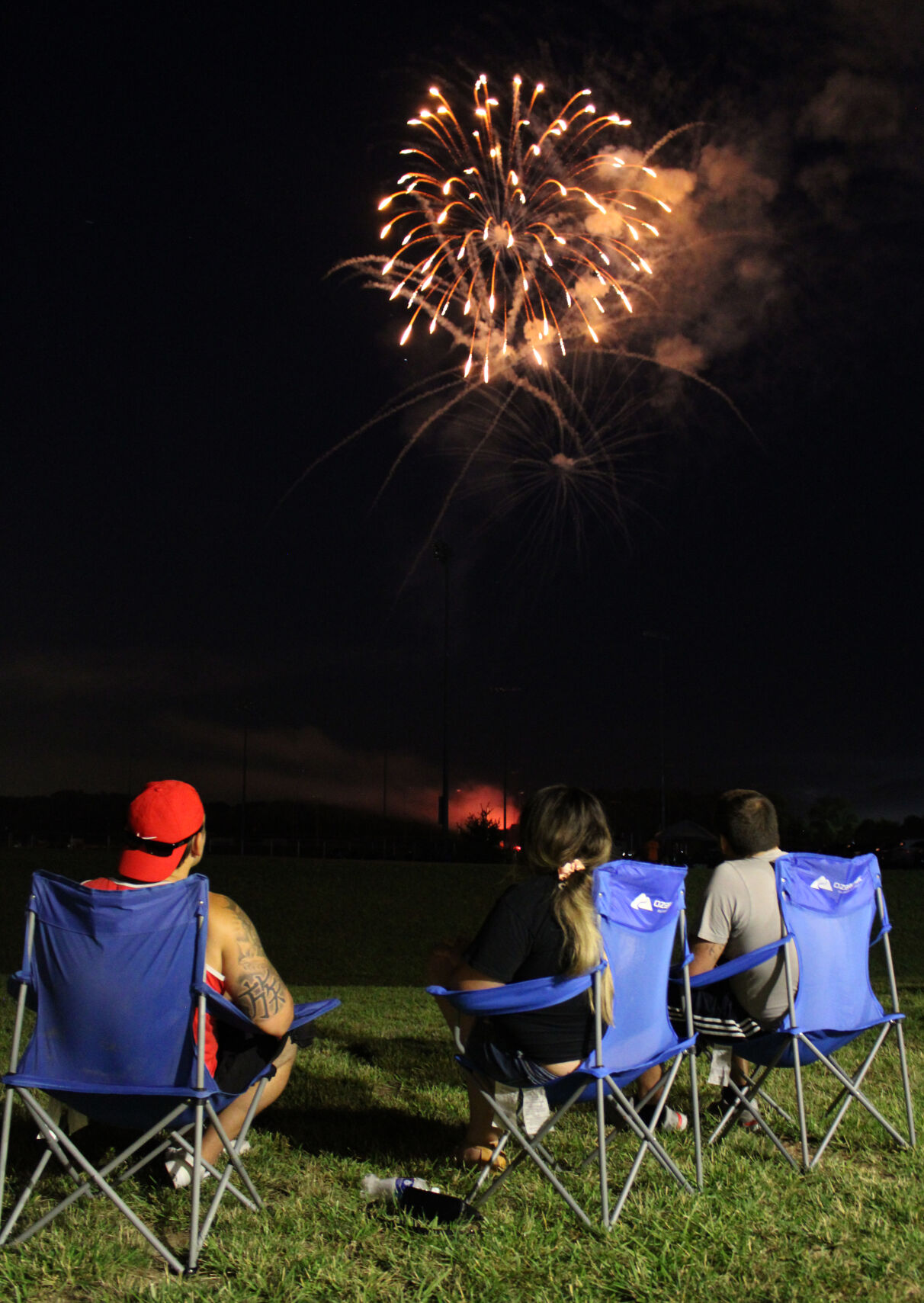 Friends in folding chairs view the fireworks